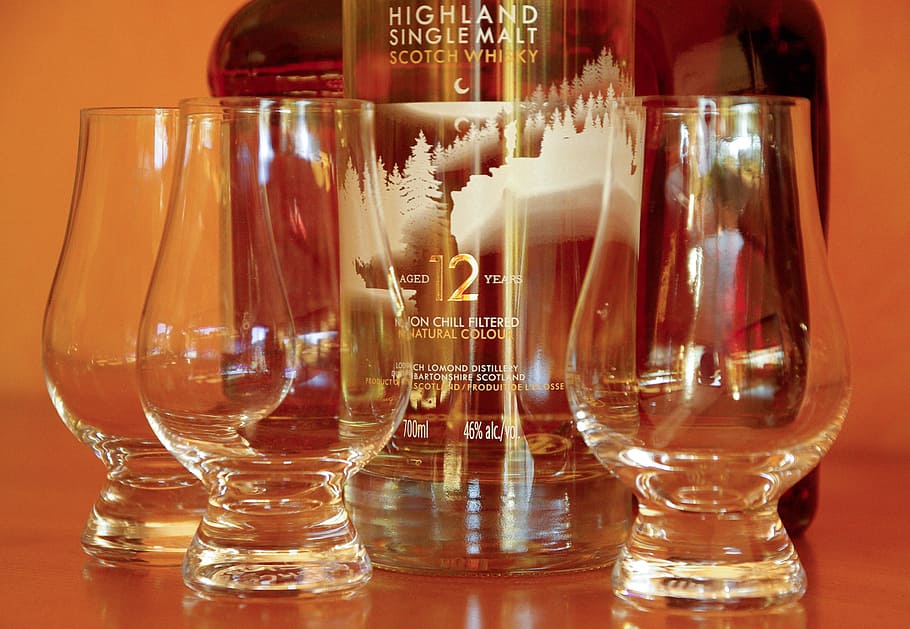Highland Single Malt Scotch Whiskey bottle near three drinking glasses
