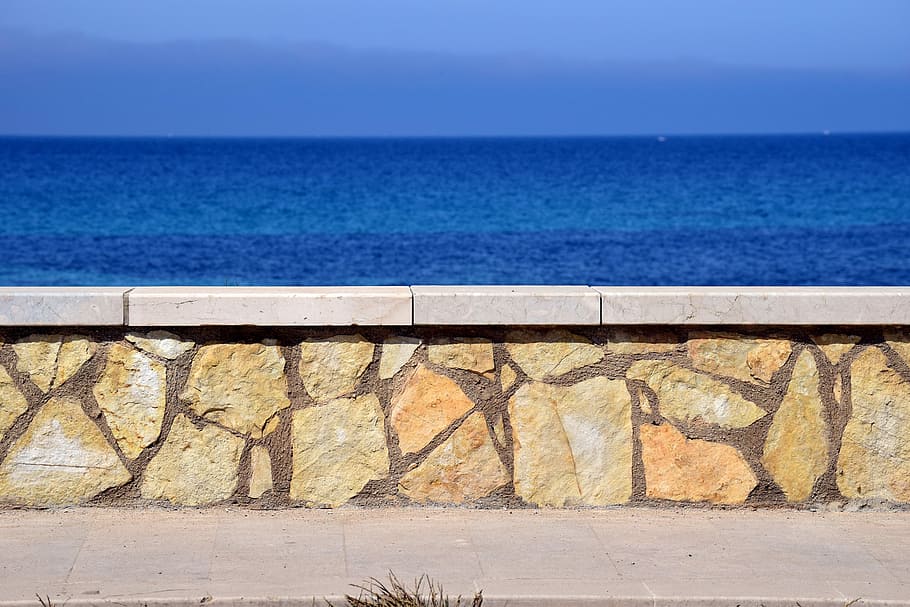 brown concrete wall near the body of water at daytime, sea, sky