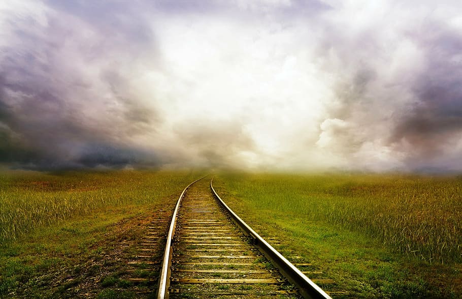 landscape photography of railway on green grass field, road, train