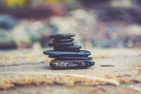 black stone arrangement in closeup photography, black stones on brown surface HD wallpaper