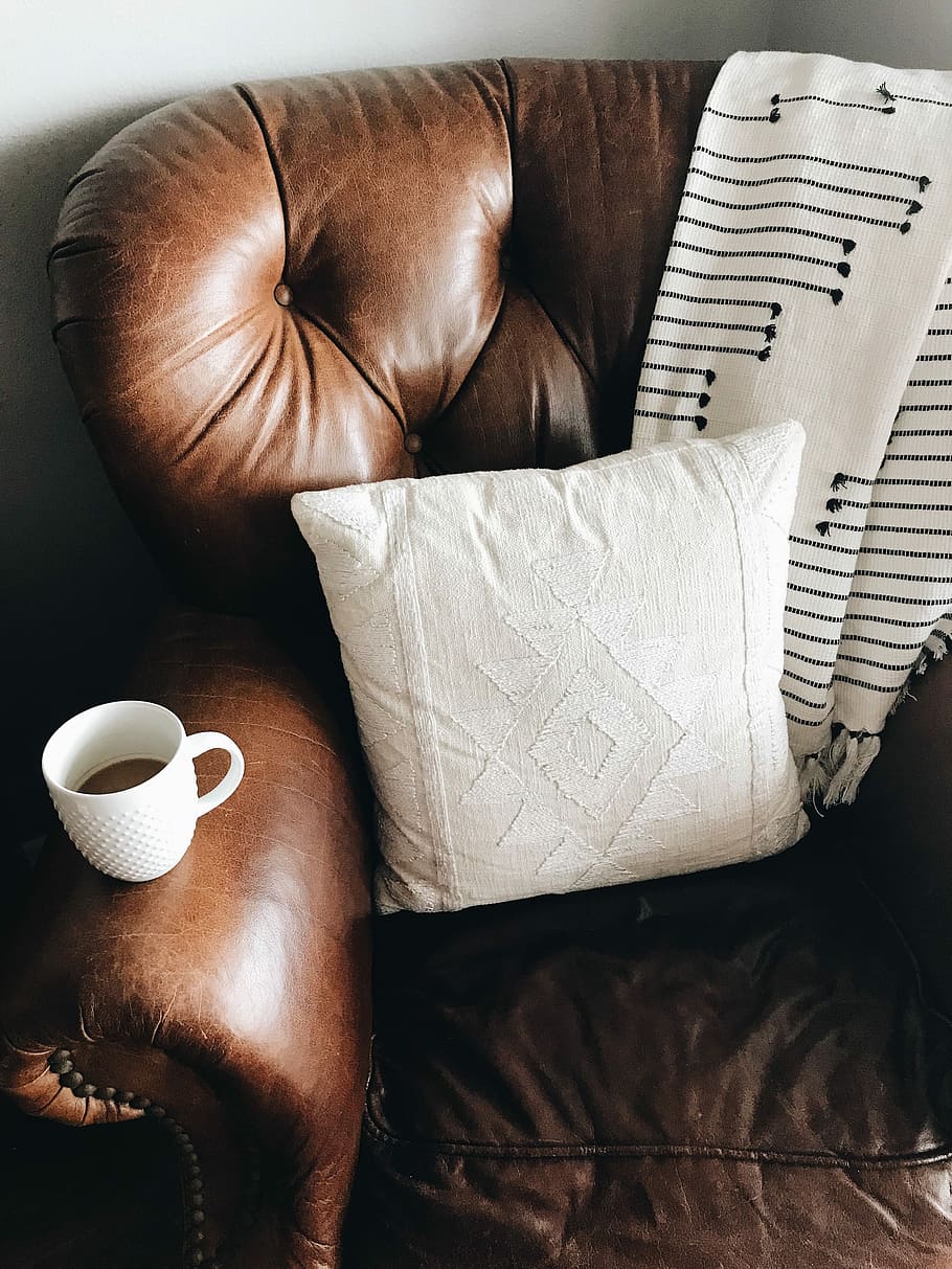 square white throw pillow on brown leather sofa chair, white throw pillow, scarf, and white ceramic mug filled with coffee on top of brown leather armchair HD wallpaper