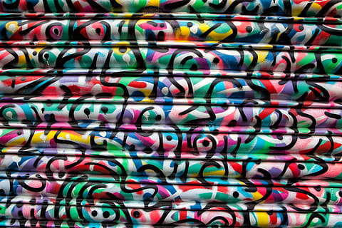 Vibrantly coloured paint swirls on a metal shop shutter, textures HD wallpaper