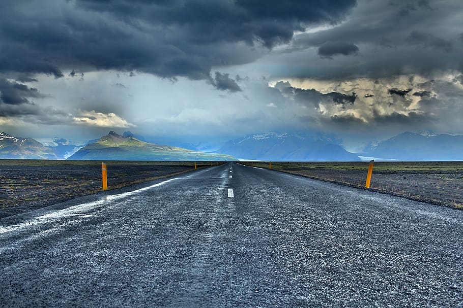 gray road under blue sky during daytime, straight asphalt road near mountain under grey clouds blue skies HD wallpaper