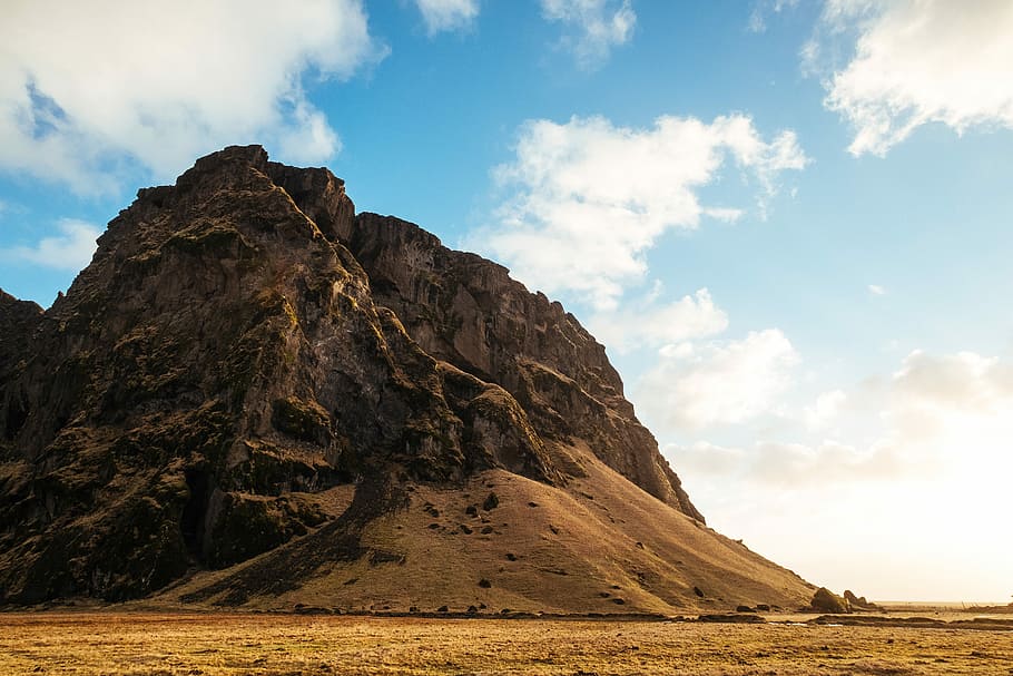 mountain under cloudy blue sky, brown stone hill under cloudy sky at daytime HD wallpaper